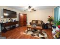 Cozy living room featuring hardwood floors, a ceiling fan, and comfortable furnishings at 1346 Revelstoke Cv, Riverdale, GA 30296