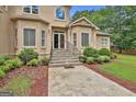 Elegant front entrance with stone steps, manicured landscaping, and a welcoming doorway at 226 Long Island Dr, Whitesburg, GA 30185