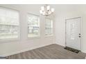 Inviting living room with new flooring, a chandelier, and ample natural light streaming through the multiple windows at 523 Mount Zion, Hapeville, GA 30354
