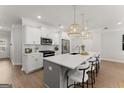 Bright kitchen with a large island, white cabinets, stainless appliances, and pendant lighting at 3349 Verdi Ln, Kennesaw, GA 30144