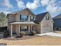 Lovely two-story brick home showcasing a covered front porch and an attached two-car garage at 10736 Southwood Dr, Hampton, GA 30228