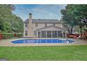 An in-ground pool is surrounded by a concrete patio and green lawn at 500 Merrill Ln, Peachtree City, GA 30269