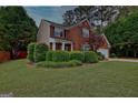 Charming two-story brick home with a well-manicured lawn and long driveway at 500 Merrill Ln, Peachtree City, GA 30269
