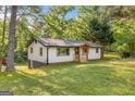 View of home with white siding, black trim, wooden porch, and a lush lawn at 474 Upper Burris Rd, Canton, GA 30114