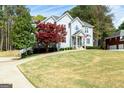 Landscaped front yard showcasing the home's curb appeal and mature trees at 165 Longshore Way, Fayetteville, GA 30215