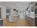 Open concept kitchen with stainless steel appliances, gray cabinets, and large waterfall island at 1240 Hayes Sq, Peachtree City, GA 30269