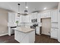 Bright kitchen features white cabinets, stainless steel appliances, and a stylish island with a granite countertop at 475 Louise Way, Locust Grove, GA 30248