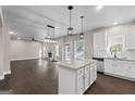 Open concept living space combines the kitchen and living room, with a cozy fireplace and ample natural light at 475 Louise Way, Locust Grove, GA 30248