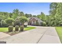 Beautiful brick home with lush landscaping, mature trees, and a long driveway at 135 Rockglen Ct, Fayetteville, GA 30215