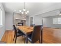 Inviting dining area with modern chandelier, wood table, stone accent wall, and hardwood floors at 23 Hunting Creek Dr, Marietta, GA 30068