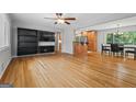 Open-concept living room featuring hardwood floors, built-in shelving, ceiling fan, and easy access to dining and kitchen at 23 Hunting Creek Dr, Marietta, GA 30068