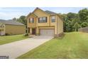 Inviting two-story home with a neutral color scheme, a two-car garage, and a well-manicured lawn at 340 Mcgiboney Ln, Covington, GA 30016