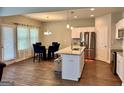Well-lit kitchen and dining area with stainless steel appliances, island, and wooden floors at 340 Mcgiboney Ln, Covington, GA 30016