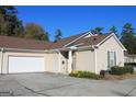 Home featuring a two-car garage and a well-maintained front yard with mature landscaping at 175 Camry Ln, Grayson, GA 30017