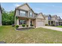 Inviting two-story home with a well-kept lawn, featuring a classic brick and siding exterior at 9046 Holder Rd, Locust Grove, GA 30248
