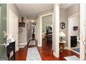 Hallway with hardwood floors, neutral paint, and several open doors at 2256 Long Bow Chase Nw, Kennesaw, GA 30144