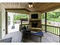 Cozy outdoor living space with a stone fireplace, comfortable seating, and a wooded view at 101 High Bluff Trl, Carrollton, GA 30116