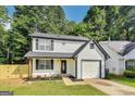 Well-maintained two-story home with a white exterior, black accents, and a neatly landscaped front yard at 131 Turning Point, Stockbridge, GA 30281