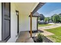 Inviting covered front porch with natural wood columns and black trim, leading to the home's entrance at 131 Turning Point, Stockbridge, GA 30281