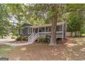 Exterior view of home featuring a porch, complemented by mature trees and a well-manicured lawn at 3404 Broxton Mill Way, Snellville, GA 30039