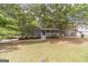 Lovely home featuring a covered front porch with mature trees providing shade at 3404 Broxton Mill Way, Snellville, GA 30039