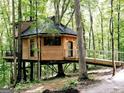 Unique treehouse retreat featuring wood siding, black trim, a metal roof, and wooded surroundings at 6290 Cascade Palmetto Hwy, Fairburn, GA 30213