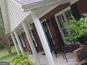 Inviting covered porch with stately columns and comfortable seating, perfect for relaxation at 920 Courthouse Rd, Temple, GA 30179