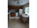 Traditional kitchen with wood cabinets, white appliances, and a dining area for casual meals at 920 Courthouse Rd, Temple, GA 30179