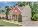 Two-story brick home with attached garage and lovely landscaped surroundings at 165 Hidden Lake Dr, Fayetteville, GA 30215