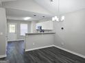 Open dining room with modern chandelier, gray walls, dark wood floors, white trim and lots of natural light at 3075 Lakeside Cir, Covington, GA 30016