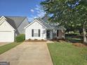 Charming single-Gathering home with light siding, black shutters, manicured lawn and mature tree in a quiet neighborhood at 3075 Lakeside Cir, Covington, GA 30016