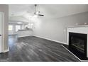 Spacious living room featuring sleek dark floors, vaulted ceiling, a cozy fireplace and an open view into the kitchen at 3075 Lakeside Cir, Covington, GA 30016