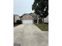 Charming two-story brick home with a two-car garage and mature landscaping at 921 Winding Down, Grayson, GA 30017