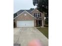 Charming two-story brick home with a two-car garage and mature landscaping at 921 Winding Down, Grayson, GA 30017