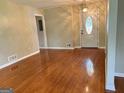 Inviting living room with hardwood floors, a decorative front door, and traditional lighting fixture at 503 Roy Huie Rd, Riverdale, GA 30274