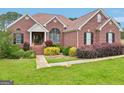 Inviting brick home featuring lush landscaping, green lawn, and classic architectural details at 1535 Lake Dow Rd, Mcdonough, GA 30252