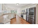 Bright kitchen featuring stainless steel appliances, white cabinets, and hardwood floors, offering modern elegance at 1535 Lake Dow Rd, Mcdonough, GA 30252