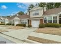 Street view showcasing a line of well-kept townhouses, each with a private garage at 124 Camry Sw Ln, Grayson, GA 30017