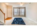 Bright living room with large windows, a cozy blue rug, and an open staircase at 124 Camry Sw Ln, Grayson, GA 30017