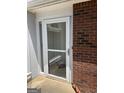Front door of home featuring a white-trimmed glass storm door and brick facade at 135 Courtyard Ln, Fayetteville, GA 30215