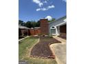 Landscaped front yard with brick edging and a walkway to the front door, shaded by trees at 135 Courtyard Ln, Fayetteville, GA 30215