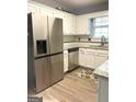 Bright kitchen with white cabinets, stainless steel fridge, and granite countertops at 165 Woodgate Cir, Fayetteville, GA 30214