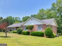 Charming brick home showcasing manicured shrubs and a well-maintained lawn, all under a sunny sky at 114 Overlook Dr, Mcdonough, GA 30252