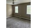 Bedroom featuring plush gray carpet, neutral paint, a ceiling fan, and two large windows at 1321 Lakeview Nw Dr, Conyers, GA 30012