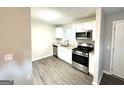 Modern kitchen features stainless steel appliances, granite countertops, and hardwood flooring at 3170 W Point Cir, Douglasville, GA 30135