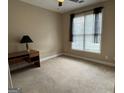 Neutral bedroom with a ceiling fan, large window, and a desk area, ready for personalization at 1031 Jordan Rd, Dacula, GA 30019
