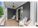 Charming front porch with seating, brick flooring, and a stylish exterior featuring gray siding at 1104 Victoria Ne St, Atlanta, GA 30319