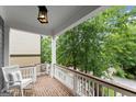 Inviting front porch with brick flooring, rocking chair, and white railings offering a relaxing outdoor space at 1104 Victoria Ne St, Atlanta, GA 30319