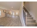 A living room features wood floors adjacent to a staircase, dining room, and kitchen at 132 Post Oak Dr St, Jackson, GA 30253
