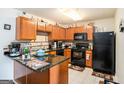 Functional kitchen equipped with black appliances, wood cabinets, and a convenient breakfast bar at 1017 Camelot Dr, Atlanta, GA 30349